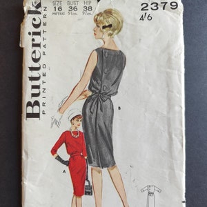 May include: Vintage sewing pattern for a dress, featuring a black dress with a tie at the waist and a red dress with a belt. The pattern number is 2379 and the size is 16, bust 36 inches, hip 38 inches.