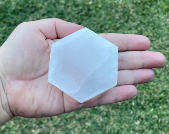 May include: A white hexagonal selenite charging plate, a crystal used for energy healing and meditation.