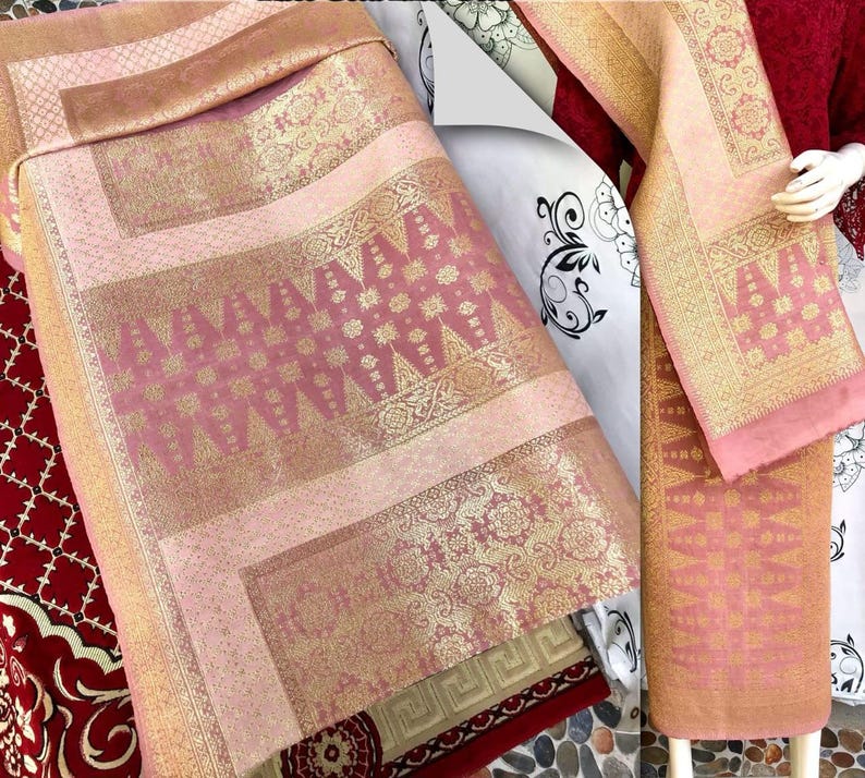 Pu&ograve; includere: Tessuto rosa e oro a motivi intricati. Il tessuto &egrave; piegato e drappeggiato, mettendo in risalto i motivi e le trame dettagliate. La tavolozza dei colori comprende sfumature di rosa, oro e marrone, creando un aspetto lussuoso.