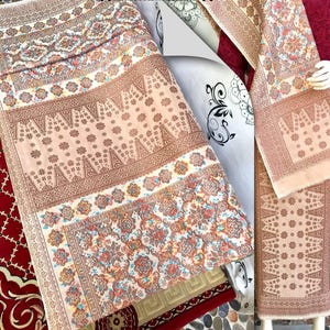 Pu&ograve; includere: Tessuti con motivi intricati nei toni del beige, marrone e rosso. I disegni presentano motivi floreali e geometrici, creando un aspetto ricco e dettagliato. I tessuti sono piegati e presentati, mostrando i loro intricati motivi.