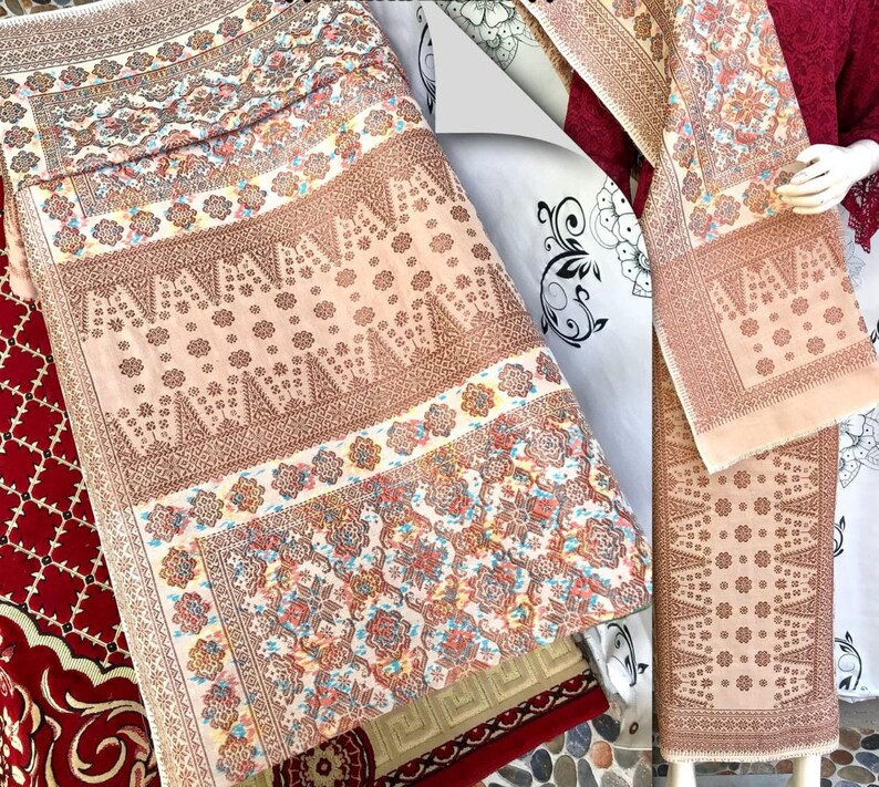 Pu&ograve; includere: Tessuti con motivi intricati nei toni del beige, marrone e rosso. I disegni presentano motivi floreali e geometrici, creando un aspetto ricco e dettagliato. I tessuti sono piegati e presentati, mostrando i loro intricati motivi.