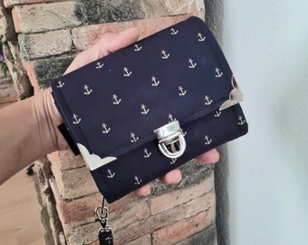 A wallet with a large circumferential coin compartment with anchor motif