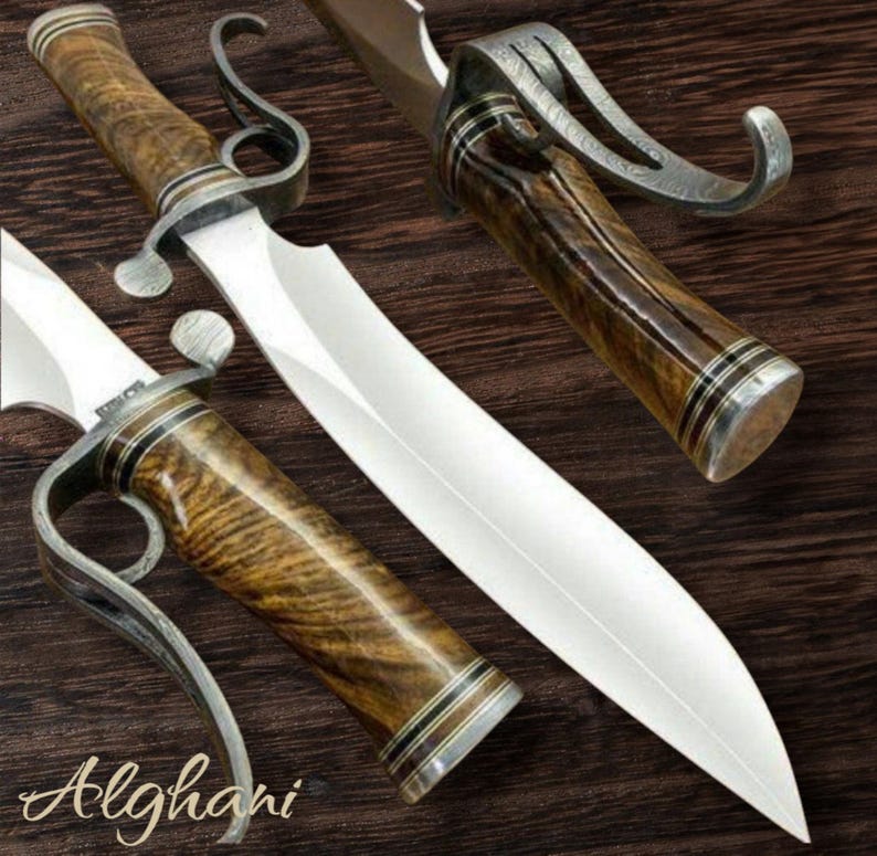 May include: A handcrafted knife with a polished steel blade and a wooden handle. The handle features a unique grain pattern and is accented with silver-colored metal. The word "Alghani" is written in cursive script near the bottom.