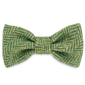 May include: A green and yellow patterned bow tie made of tweed fabric.