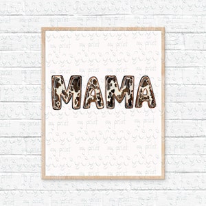 Puede incluir: Una impresi&oacute;n enmarcada con la palabra "MAMA" en letras marrones y blancas con estampado de vaca. Las letras tienen un contorno dorado.