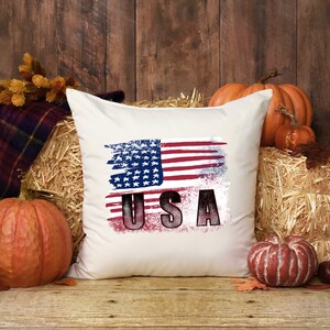 Distressed red white and blue American flag design shown on a white pillow mockup.
