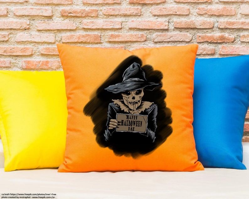 Peut inclure: Un coussin orange avec une illustration en noir et blanc d'un &eacute;pouvantail tenant une pancarte qui dit "Joyeux Halloween".