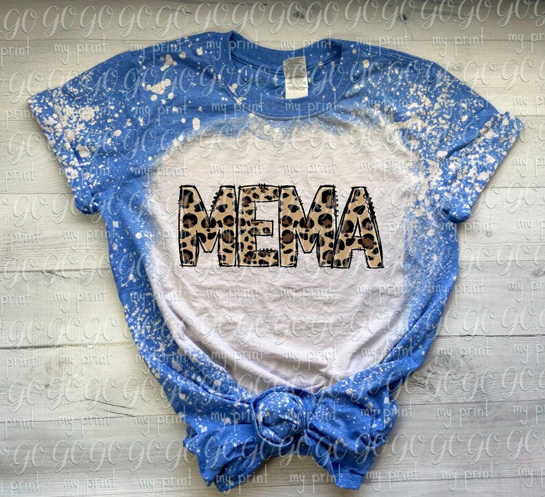 K&ouml;nnte beinhalten: Ein wei&szlig;es T-Shirt mit einem blauen Bleichdesign und dem Wort "MEMA" in Leopardenmuster.