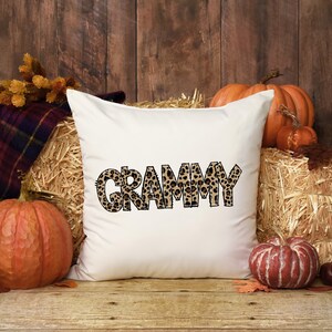 Grammy leopard print lettering displayed on a white pillow in an autumn home decor mockup.
