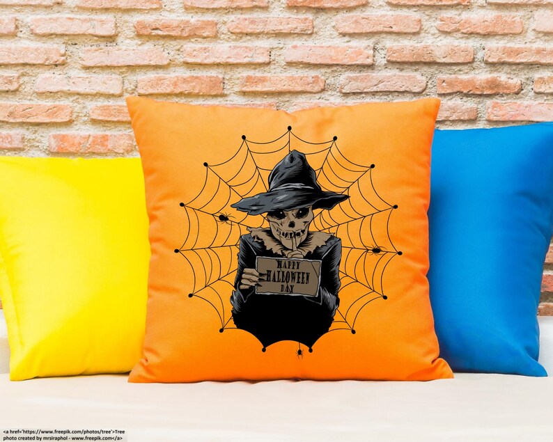 K&ouml;nnte beinhalten: Ein orangefarbenes Kissen mit einem gruseligen Halloween-Motiv. Ein Skelett mit Hexenhut h&auml;lt ein Schild mit der Aufschrift "Happy Halloween Day" und ist von einem Spinnennetz umgeben.