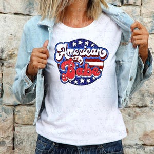 Woman wearing a white shirt featuring the retro American Babe red white and blue patriotic design.