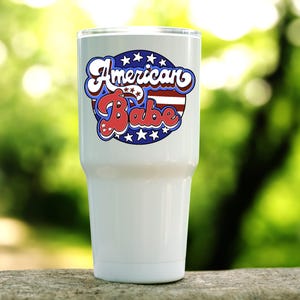 American Babe stars and stripes retro patriotic design shown on a white tumbler.