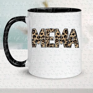 K&ouml;nnte beinhalten: Eine wei&szlig;e Keramiktasse mit schwarzem Henkel. Die Tasse hat ein Leopardenmuster, das "MEMA" buchstabiert.