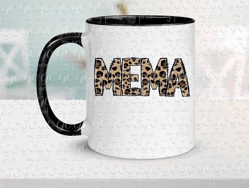 K&ouml;nnte beinhalten: Eine wei&szlig;e Keramiktasse mit schwarzem Henkel. Die Tasse hat ein Leopardenmuster, das "MEMA" buchstabiert.