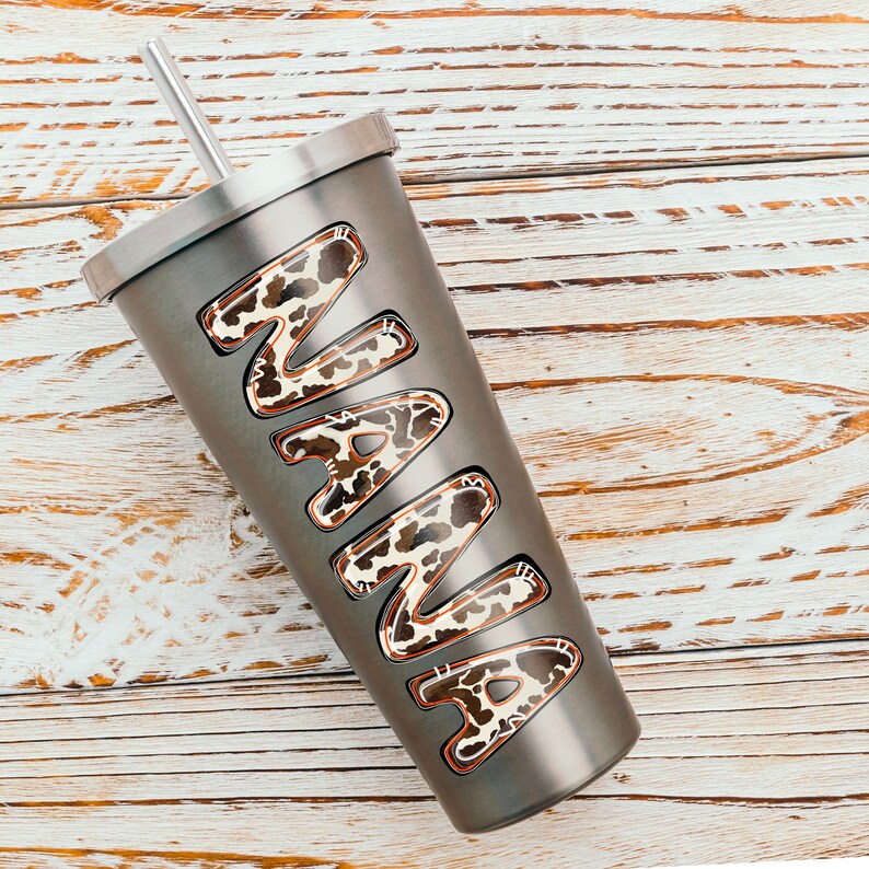 Puede incluir: Un vaso de acero inoxidable con una pajita y un dise&ntilde;o de estampado de leopardo que dice "NANA" en &eacute;l.