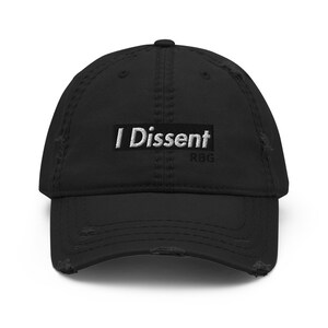 May include: Black distressed baseball cap with white embroidered text "I Dissent" and the initials "RBG" in smaller text below.