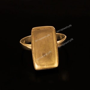 Peut inclure: Bague en or avec un sertissage rectangulaire vide. La bague est prête à être personnalisée avec une pierre ou un autre ornement.