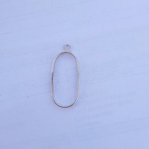 May include: A silver oval-shaped pendant with a small loop at the top.