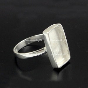 Op de afbeelding: Een zilveren ring met een rechthoekige bezel-setting. De ring is ontworpen om een cabochon-steen te houden.