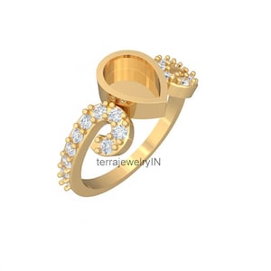 May include: A gold-colored ring with a teardrop-shaped setting and a swirling design. The ring is adorned with small, round, clear gemstones. The text "terrajewelryIN" is visible on the ring.