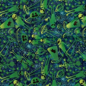 May include: Fabric with a repeating pattern of green aliens, UFOs, and planets on a dark blue background with white stars. The aliens are in various poses, some with outstretched arms. A ruler is at the bottom of the image.
