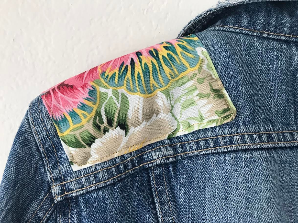 Denim jacket with custom embellishment using Hawaiian themed fabric