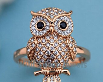 May include: A gold-tone ring featuring a detailed owl design with clear and black rhinestones. The owl is perched on a branch with its wings spread.