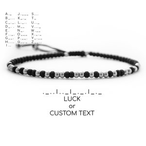 May include: A black and silver beaded bracelet with a string closure. The bracelet has the word "LUCK" written on it, and the option to customize with text.