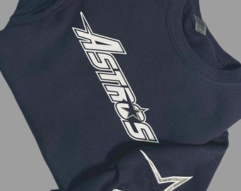 Op de afbeelding: Donkerblauwe trui met een wit "Astros" logo en een zilveren glitterster op de mouw.