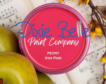 May include: A can of Peony (Hot Pink) paint from Dixie Belle Paint Company. The can is a vibrant pink color with a matching pink rim. The text is in a script font. The can is surrounded by yellow pears and sheet music.