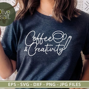 May include: A dark blue t-shirt with white text that reads "Coffee & Creativity" with a stylized coffee cup and a cinnamon stick.