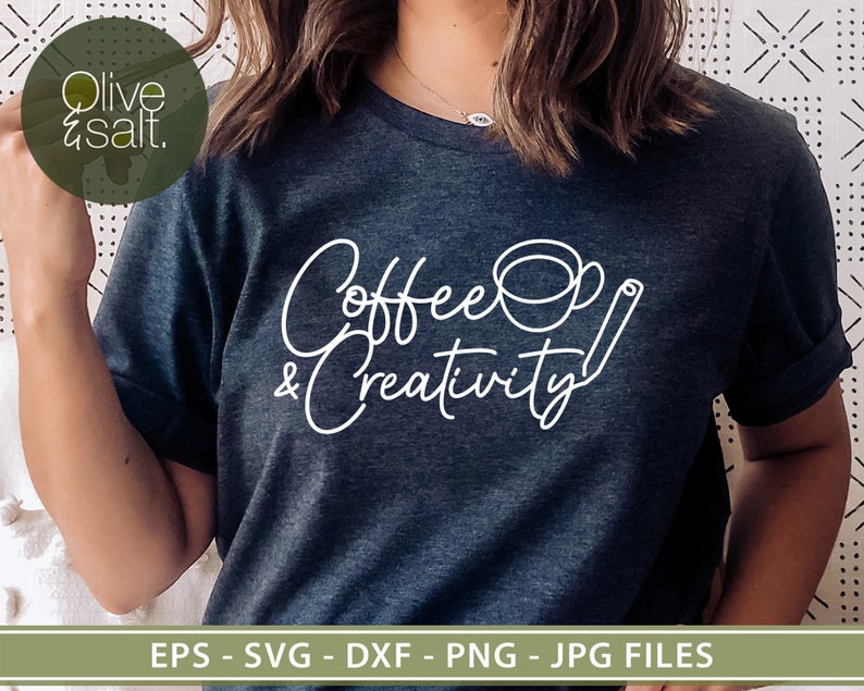 May include: A dark blue t-shirt with white text that reads "Coffee & Creativity" with a stylized coffee cup and a cinnamon stick.