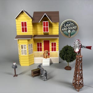 May include: A yellow two-storey dollhouse with a brown roof, red doors and windows, and a white porch. The house is surrounded by miniature farm animals, a windmill, and a mailbox. The dollhouse has lights and sound.