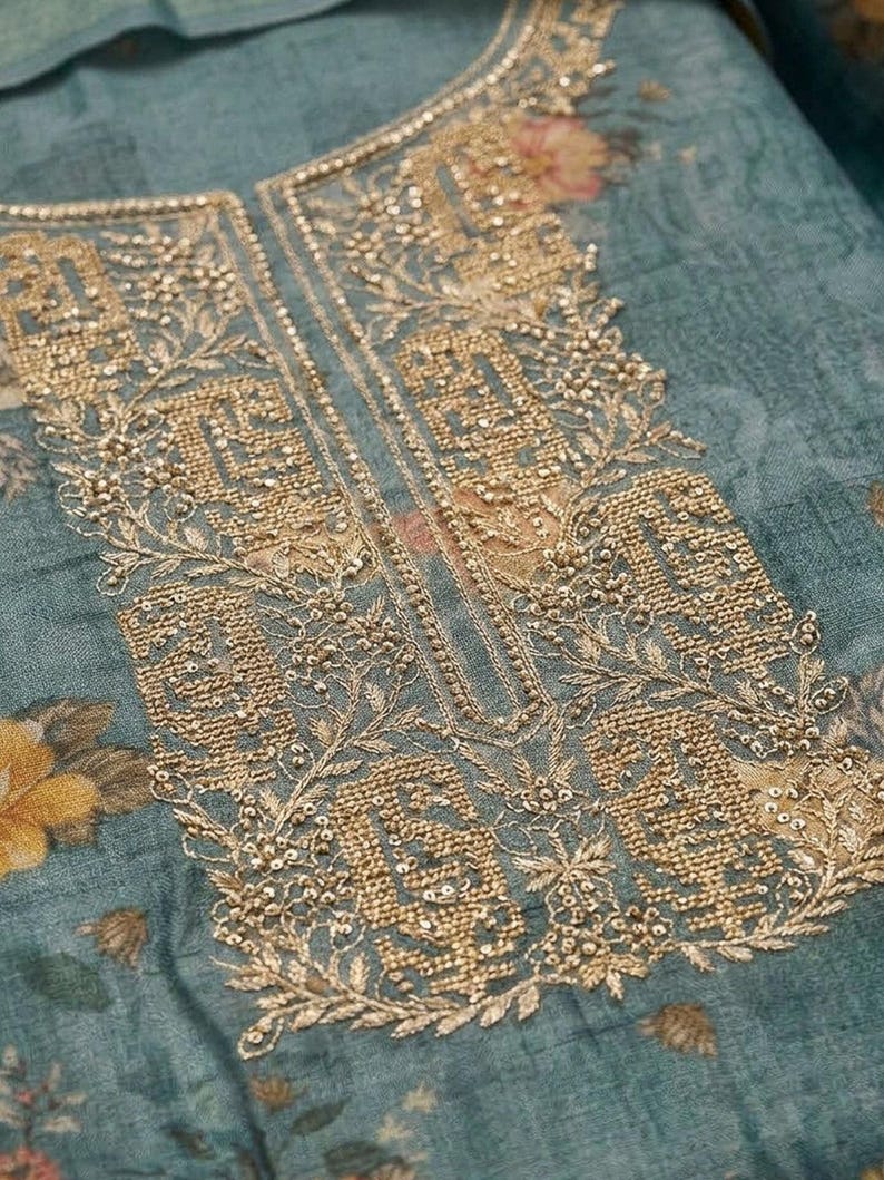 May include: A teal fabric garment featuring an intricate gold metallic embroidery pattern around the neckline. The embroidery consists of dense geometric shapes, floral motifs, and small beads. The base fabric has a muted floral print.