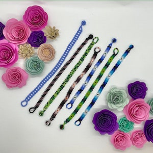 May include: A set of eight colorful beaded bracelets with various patterns. The bracelets are made with small, colorful beads and have a simple, elegant design.