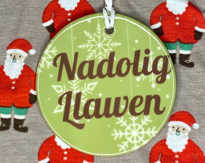 Addurn seramig i’w hongian ar goedenNadolig efo dyluniad ‘Nadolig Llawen’ ceramic hanging tree decoration