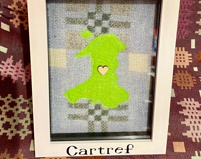 Map Cymru ar ffabrig Cymreig  mewn ffram bocs/ Wales map on Welsh blanket fabric  mounted in a 7x5 box frame with wording ‘Cartref’