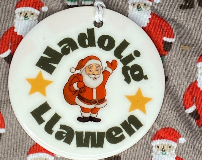 Addurn seramig i’w hongian ar goedenNadolig efo dyluniad ‘Nadolig Llawen’ ceramic hanging tree decoration