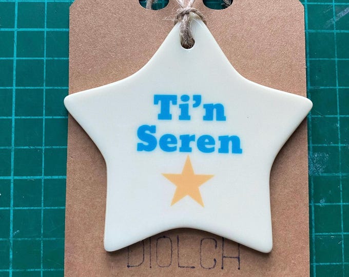 Addurn seramig i’w hongian efo dyluniad ‘Ti'n Seren’ ceramic hanging  decoration with the Welsh words for 'You're a Star'