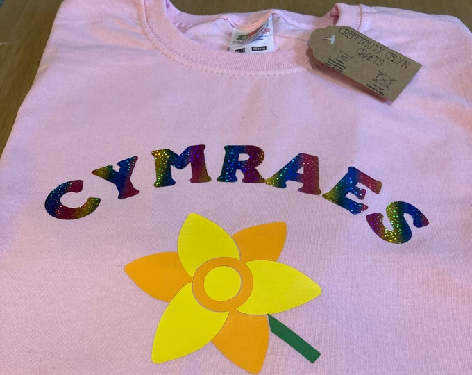 Crys T pinc ‘Cymraes’ i ferched efo llun cennin pedr/ Pink Welsh girls T shirt with the word Cymraes (Welsh(girl)) & picture of daffodil.