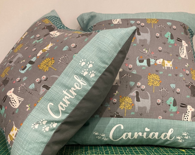 Clustog ffabrig patrwn ci efo dewis o’r gair ‘Cartref”, “Cariad “ neu gellir personaleiddio efo enw o’ch dewis.