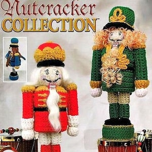 May include: Two crocheted nutcracker dolls. The doll on the left is wearing a red and gold uniform with a white beard. The doll on the right is wearing a green uniform with a gold hat and a white beard. Both dolls are standing on a drum.