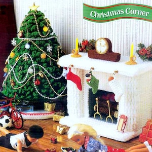 May include: A crocheted Christmas scene with a green Christmas tree, a white fireplace with stockings, and a clock on the mantel. The text "Christmas Corner" is on a banner above the fireplace.