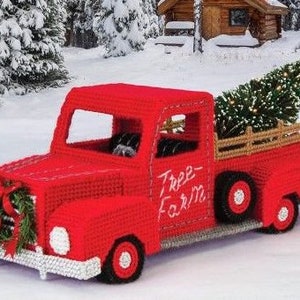 May include: A red toy pickup truck with a Christmas tree in the back. The truck has a wreath on the front and the words "Tree Farm" written on the side.