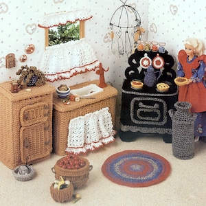 May include: A miniature dollhouse kitchen set with crocheted furniture, including a stove, sink, cabinets, and a rug. The set is decorated with red and white accents and includes a doll figurine.