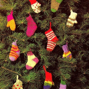 May include: A Christmas tree decorated with colorful crocheted mitten and stocking ornaments. The ornaments are made in a variety of colors, including red, green, yellow, blue, and purple.