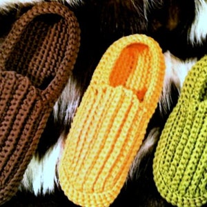 May include: Three pairs of crocheted slippers in brown, yellow and green. The slippers are made with a simple stitch and have a rounded toe.