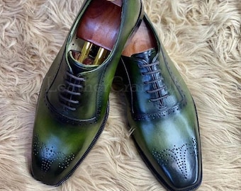 May include: A pair of green leather lace-up shoes with brogue detailing. The shoes have a pointed toe and a closed lace-up design.