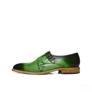 May include: Green leather double monk strap dress shoes with a brown leather sole.