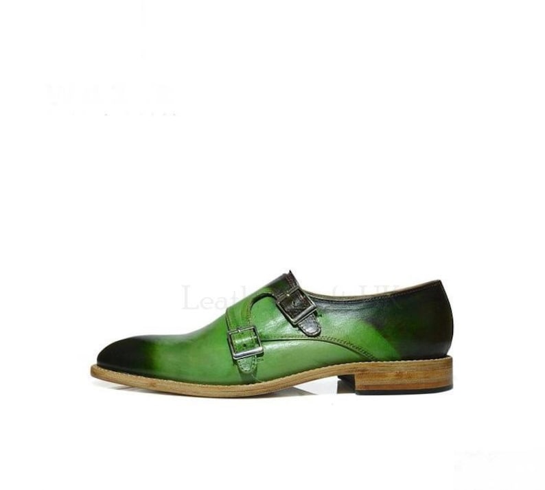 May include: Green leather double monk strap dress shoes with a brown leather sole.